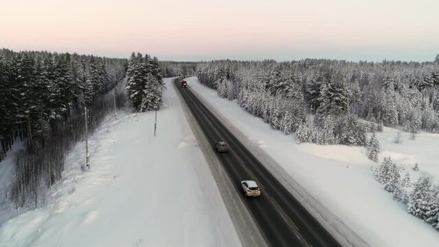 Top view of cars driving on a snow covered icy road exploring the local scenery in winter.