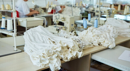 Industrial sewing production or atelier. A stack of fabric that requires sewing. The process of creating ready-made clothing models.