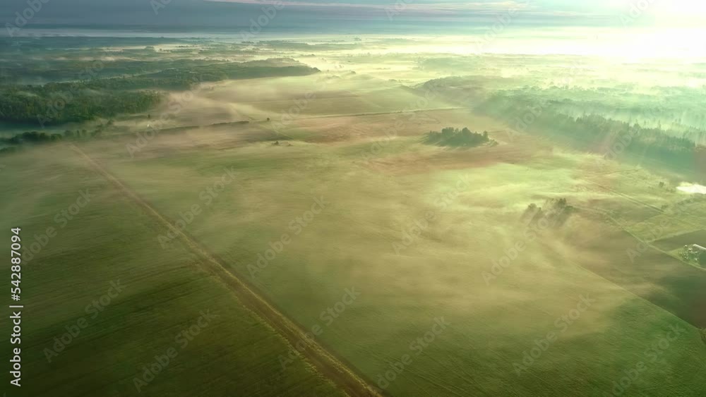 Poster high altitude aerial view overlooking a vast landscape with forests and fields covered in fog. a mag
