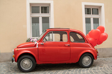 kleines rotes Auto mit roten Luftballons
