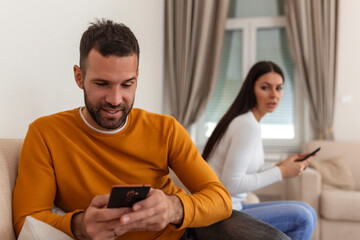 Jealous suspicious mad wife arguing with obsessed husband holding phone texting cheating on...