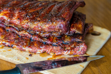 Tasty grilled ribs with knife on table