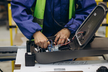 Worker in production. Production of street lanterns. Machine