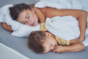Fototapeta na wymiar Young mother with 4 years old son in bed