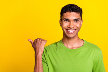 Closeup photo of young smiling handsome guy finger pointing empty space demonstrating new...