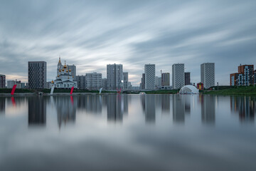 Yekaterinburg city skyline. Buildings of the Academichesky district reflects in mirror surface of the pond.