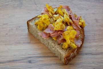 Scrambled eggs with ham on a slice of bread
