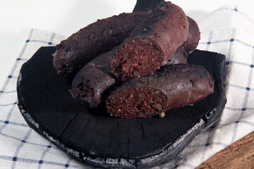 Baked blood sausage. Buckwheat sausage. Blood bloody sausages on wooden cutting board. Homemade black pudding