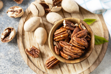 Bowl with pecan nuts on a stone table. Nuts and seeds, healthy fats, various trace elements and vitamins.
