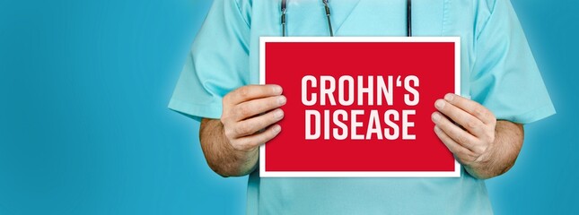 Crohn's disease. Doctor shows red sign with medical word on it. Blue background.