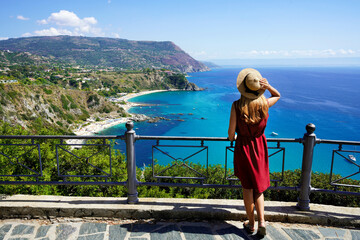 Tourism in Italy. Panoramic view of young woman with hat in Capo Vaticano on the Coast of the Gods,...