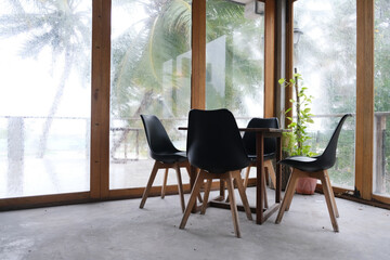 The table and chair set in an empty space with outdoor raining scene at Rashdoo, Maldives.