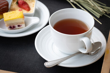 Afternoon tea in a white cup with dessert. English traditional drink. Tasty beverage.