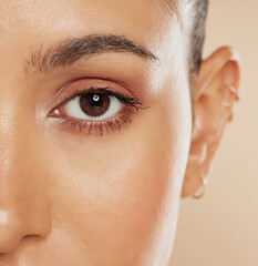 Eye, vision and beauty with a model woman closeup in studio on a beige background for eyecare or skincare. Zoom, cosmetics and wellness with a female posing to show her eyelash, eyebrow or pupil
