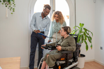 Multicultural businesspeople discussing business strategy with their colleague in the wheelchair...