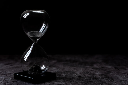 Elegant hourglass on a dark background - concept passage of time, calmness, elegance