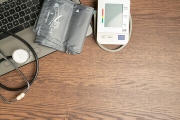 top shot of a digital blood pressure monitor and stethoscope on a laptop. Health concept