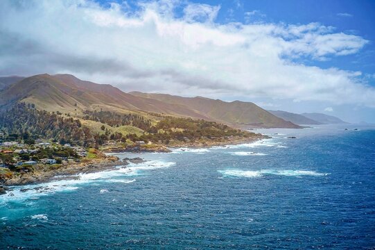 Foamy Waves Hitting The Big Sur Coastline In California Against The Santa Lucia Mountains