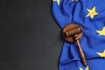 Wooden judge's gavel and flag of European Union on black table, flat lay. Space for text