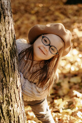 Happy child with down syndrome enjoying in autumn park