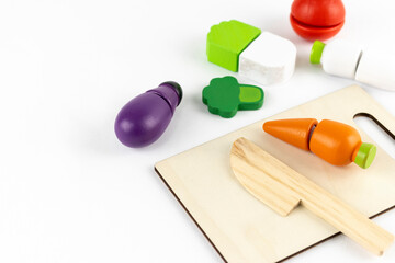 木のオモチャの野菜と包丁とまな板。料理のイメージ