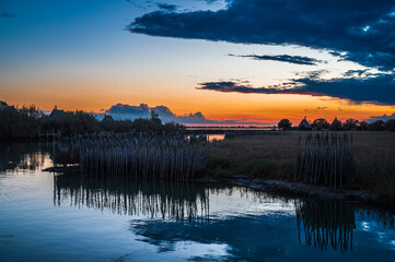 Towards the sunset. Marano lagoon late summer colors. Clouds and sun