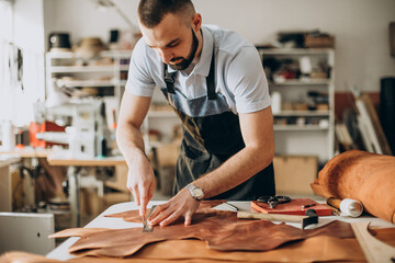 Male designer and leather tailor working at a factory