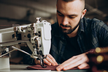 Male designer and leather tailor working at a factory