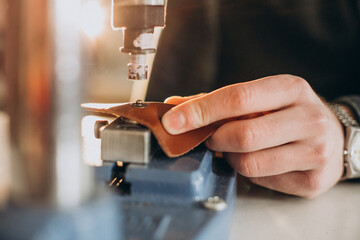 Male designer and leather tailor working at a factory close up