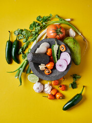 Ingredientes mexicanos en fondo amarillos con molcajete 