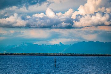 Towards the sunset. Marano lagoon late summer colors. Clouds and sun