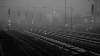 Rote Signale in einem Bahnhof bei Nacht und bei Nebel