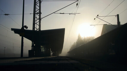 Kleiner Bahnhof und Bahnsteig im Morgengrauen und Gegenlicht
