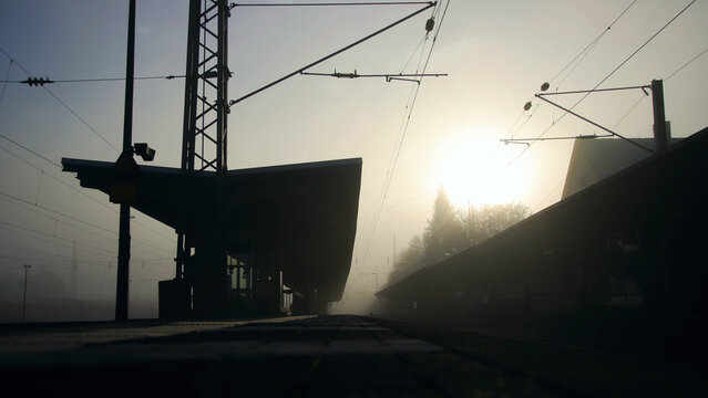 Kleiner Bahnhof und Bahnsteig im Morgengrauen und Gegenlicht