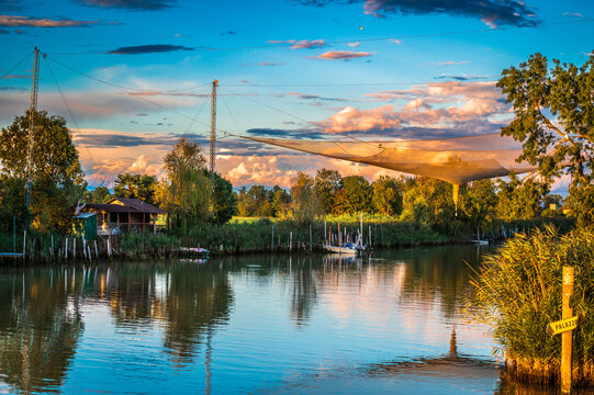 Towards the sunset. Marano lagoon late summer colors. Clouds and sun