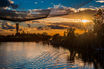 Towards the sunset. Marano lagoon late summer colors. Clouds and sun