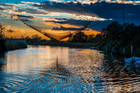 Towards the sunset. Marano lagoon late summer colors. Clouds and sun