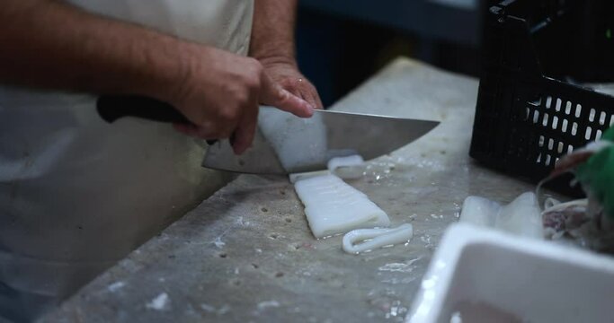 Fish monger preparing fish inside seafood market