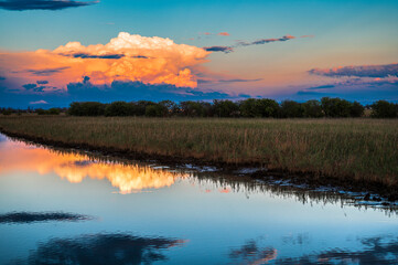 Obraz na płótnie Canvas Towards the sunset. Marano lagoon late summer colors. Clouds and sun