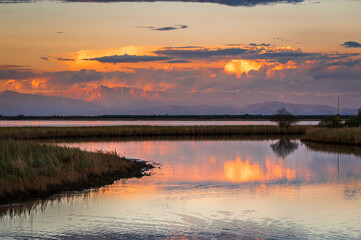 Towards the sunset. Marano lagoon late summer colors. Clouds and sun