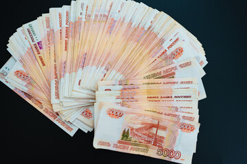 a fan of banknotes of 5000 rubles on a black background. 