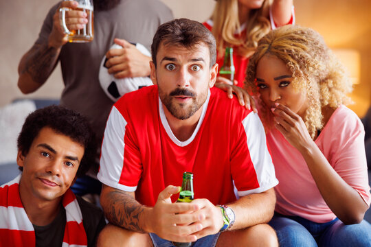 Football fans watching game on TV disappointed after their team loosing