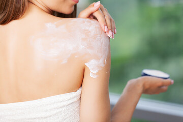 Fototapeta premium Happy woman doing routine skin care at home with beauty products.
