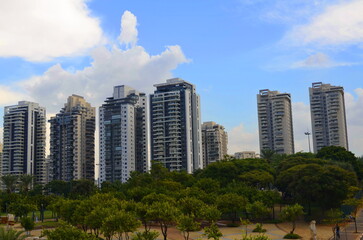 Modern residential area in Israel. Apartment buildings, housing stock, real estate for families. New buildings next to the park, palm trees and greenery