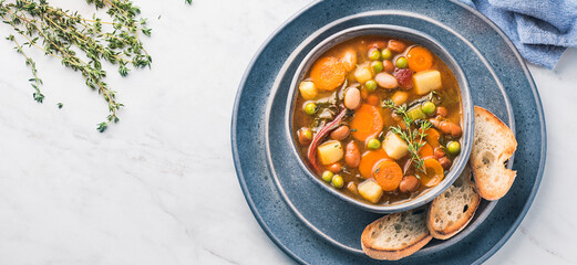 Minestrone vegetable soup with pieces of toasted bread and herbs. Simple vegan rustic Italian dish, classic of Italian cuisine, delicious healthy Mediterranean lunch. Internet banner