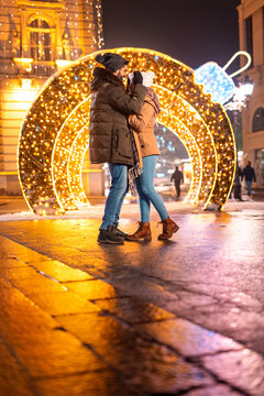 Couple hugging in city square for Christmas