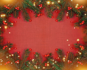 Fototapeta na wymiar Spruce, fir branches, red berries, gift on textured red background. Frame border. Christmas New Year composition background. Xmas greeting card. Space for text.
