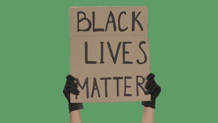 Hands of an unknown person in black gloves raise cardboard poster BLACK LIVES MATTER. Stop Racism concept, No Racism. Peaceful life of blacks matters. Isolated green screen chroma key. © kinomaster