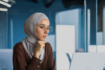 Businesswoman thinking and sad, looking at laptop screen close up, female worker in glasses and...