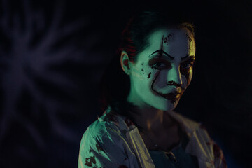 Portrait of young woman in image bloodthirsty zombie with horror wounds and bloody clothes.